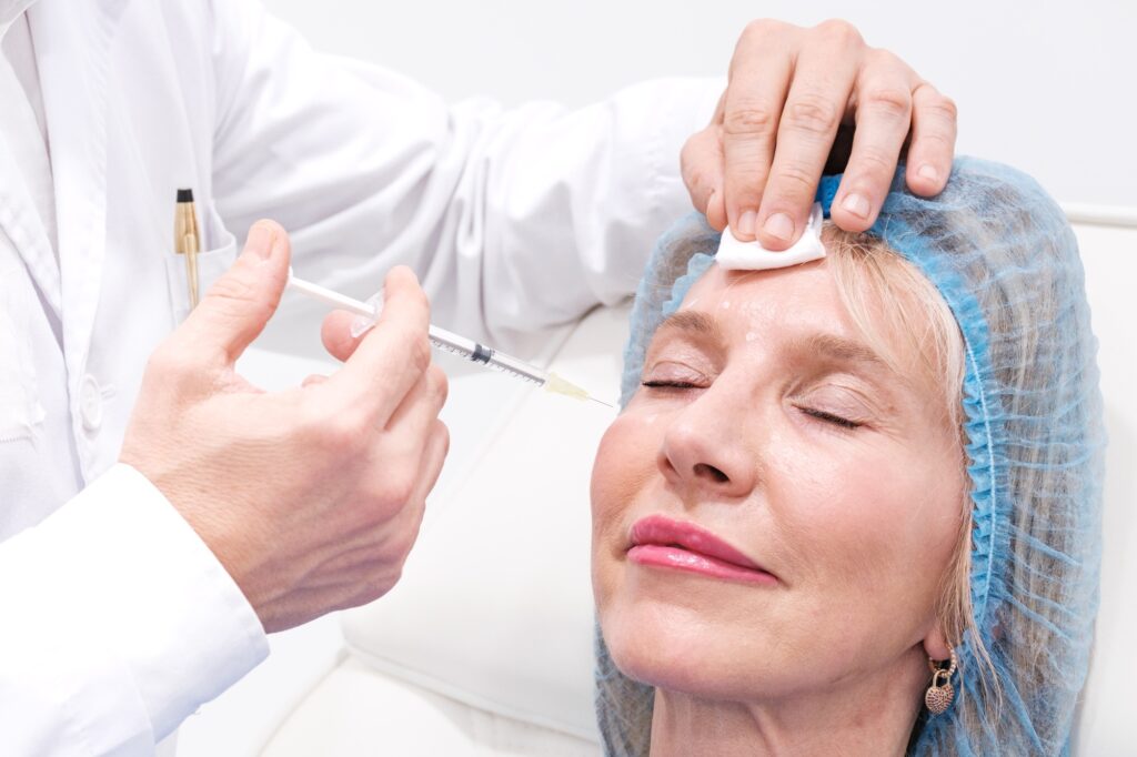 Close up picture of hand applying acid hyaluronic to a woman