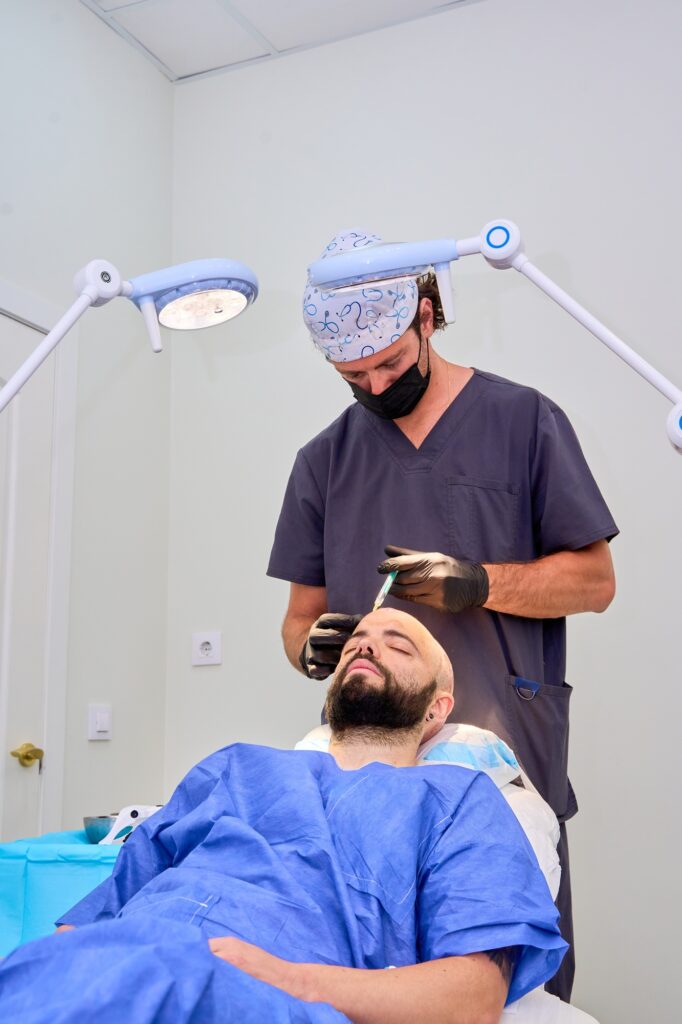Doctor administering scalp injection during a hair transplant procedure on a patient